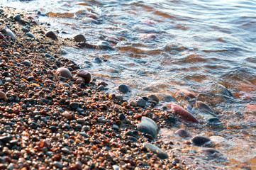 Rocks on the seashore. The sandy shore of the sea. Waves on the Baltic Sea.
