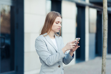Fototapeta premium Young woman wearing casual using smartphone outdoor