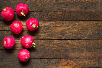 Red whole radishes on wooden table with copy space