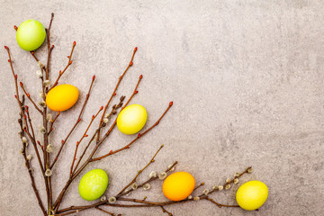 Easter eggs concept with willow seals branches. On a stone background, copy space, top view.