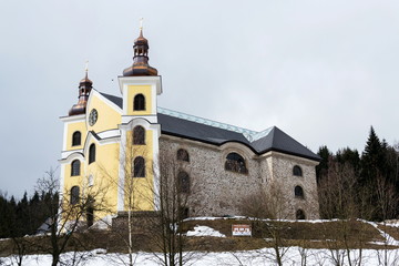Fototapeta premium Church of Assumption with glass roof in snowy mountains country, Neratov, Orlicke hory, Eagle Mountains, Czech republic