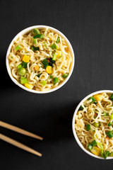 Tasty instant ramen noodles with beef flavoring over black surface. Flat lay, from above, overhead. Close-up.