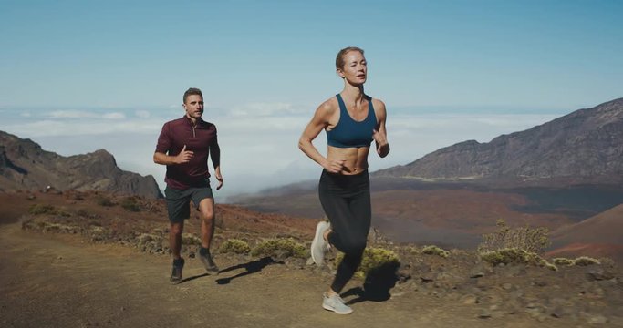 Trail running in the mountains, young athletic man and woman working out in the outdoors, running adventure lifestyle