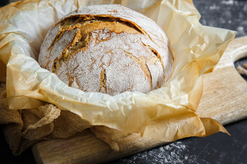 white bread on wooden board and in black background.