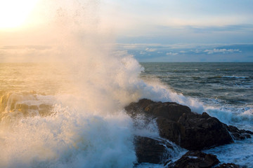 Seascape. Waves of the Atlantic Ocean crashing against a rock at sunset. Portugal