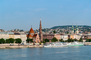 Fototapeta na wymiar Szilagyi Dezso Square Reformed Church on the banks of the Danube River with St Anne's church in background - Budapest, Hungary