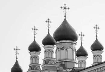 Copper domes with gilded crosses of the Christian church against the blue sky.