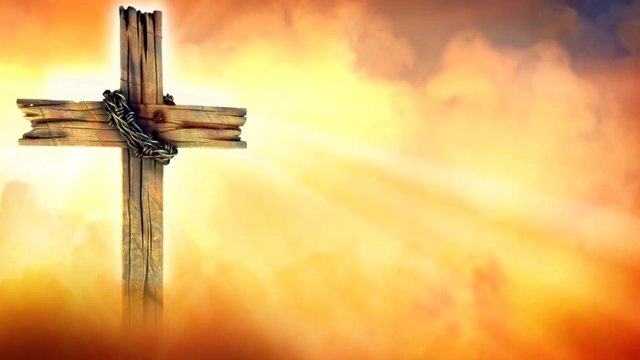 Golden Morning Cross Silhouette with Light Beams 4K Loop features golden clouds and smoke moving across the scene and around a wooden cross
