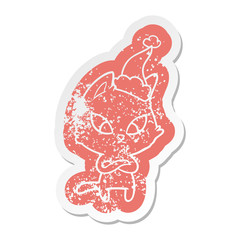 confused cartoon distressed sticker of a cat wearing santa hat