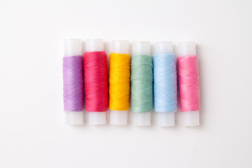 Multicolored thread coils on white background. Sewing supplies and accessories for needlework, stitching, embroidery. copyspace. flat lay. top view