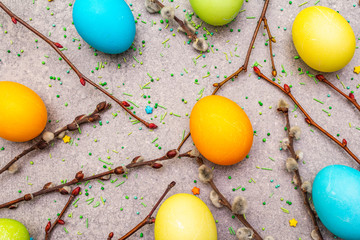 Easter eggs concept willow seals branches, sweet topping on a stone background wallpaper, top view, close up.