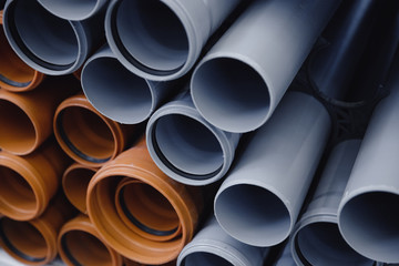 PVC plastic construction pipes for water are displayed in row on counter