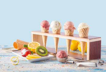 ice cream varieties in cornet with fruits on blue table © Memed ÖZASLAN