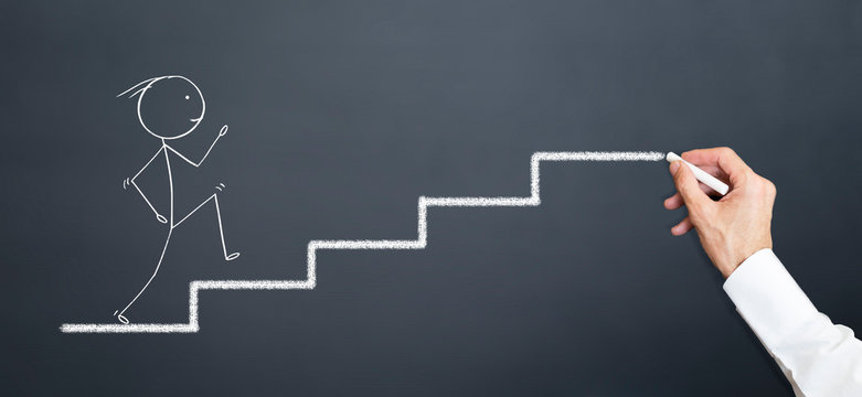 leader draws stairs on blackboard with chalk. man climbing stairs