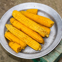 Boiled corn on an aluminum tray. Yellow boiled young corn, useful and tasty food