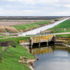 Fototapeta na wymiar Bridges through irrigation canals. Rice field irrigation system