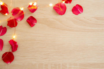 valentines day background with red rose petals on vintage wooden table