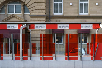 Das Eislokal eines Luxushotels mit rotem und durchsichtig designtem Plexiglas außen an einer Durchfahrt. .