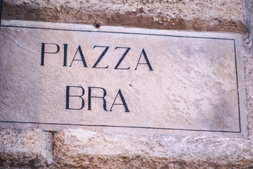 Piazza Bra street name sign, the largest piazza in Verona, Italy. The Verona Arena and Verona's town hall (The Gran Guardia) look out across the piazza