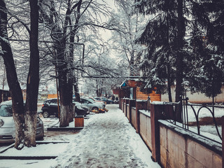 Winter noon. People walk in the snow. Snowy street. Mountain ski resort Bakuriani