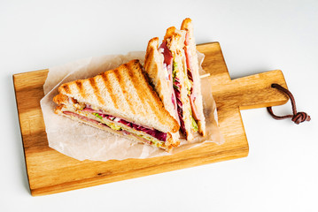 Sandwich with ham, cheese, tomatoes, lettuce, and toasted bread.