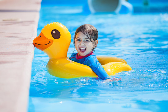 Kind mit einer Gummiente im Schwimmbad
