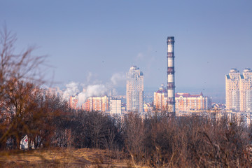 Fototapeta na wymiar Early spring at sunny evening in warm weather. Industrial zone and residential areas Podin and northern suburbs Obolon in Kyiv on the right bank of the Dnipro River. Ukraine Mar. 6, 2019