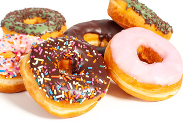 Colorful glazed donuts on white background.
