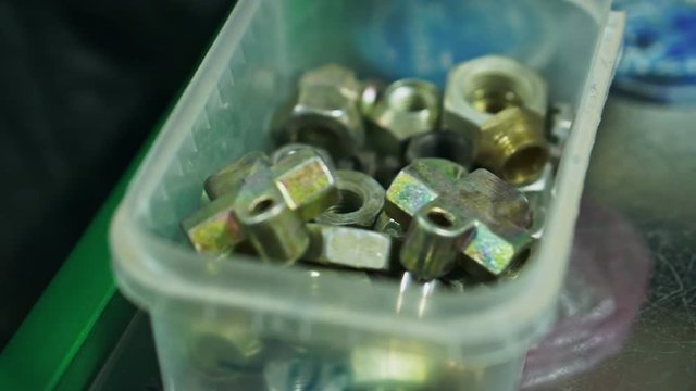 Men chooses nuts for car parts close up