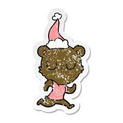 peaceful distressed sticker cartoon of a bear running wearing santa hat