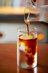 Pouring coffee in iced water 