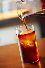 Pouring coffee in iced water 