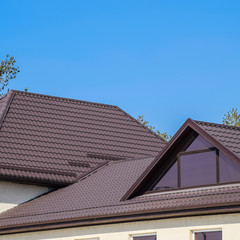 House with plastic windows and a brown roof of corrugated sheet