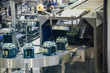 Automated beer bottling production line. Packed beer bottles on conveyor belt