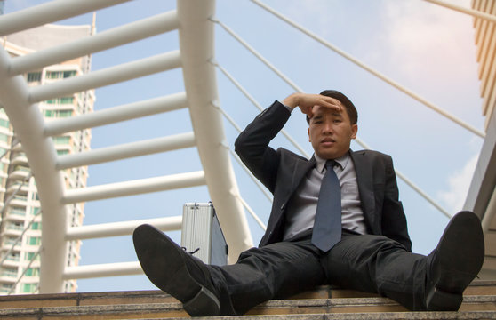Business concept : businessman stress job sitting on the walkway in the city. - Powered by Adobe