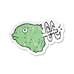 retro distressed sticker of a cartoon fish head