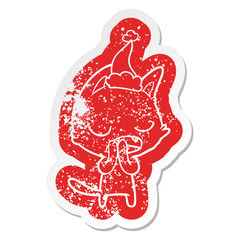 talking cat cartoon distressed sticker of a wearing santa hat