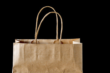 Paper shopping bag isolated on black background.