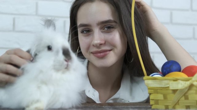 Easter holiday. Pretty girl with a basket of Easter eggs and an Easter bunny.