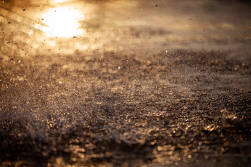 Splashes of water and bokeh of Water on a Sunset Background.