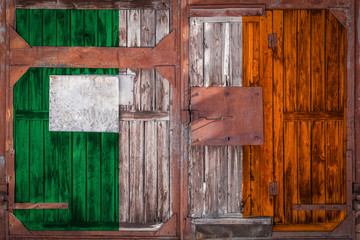 Close-up of old warehouse gate with national flag of ireland. The concept of export-import Ireland,...