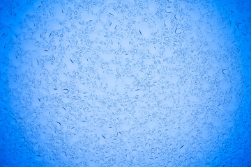 Rain droplets on blue glass background, Water drops on blue glass.