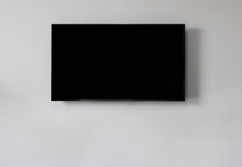 Smart TV on white wall, blank black screen