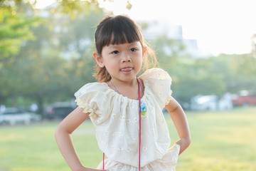 one girl 4-5 year old in yellow Thai dress is playing at outdoor,she looks happy