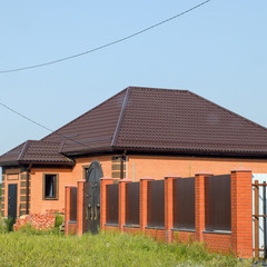 The house with plastic windows and a roof of corrugated sheet