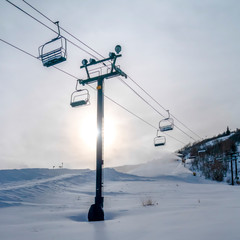 Ski lifts against mountain and sun in Park City