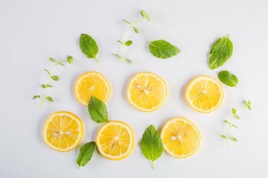 Lemon slices and mint leaves on white background