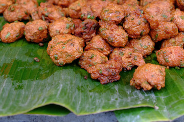 Pile of deep fried fish pancake food on fresh banana leaf
