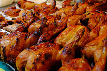 Grilled whole chickens in rows prepared for meal
