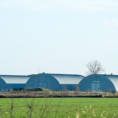 Fototapeta na wymiar Three hangars in the field. Hangars from galvanized iron.